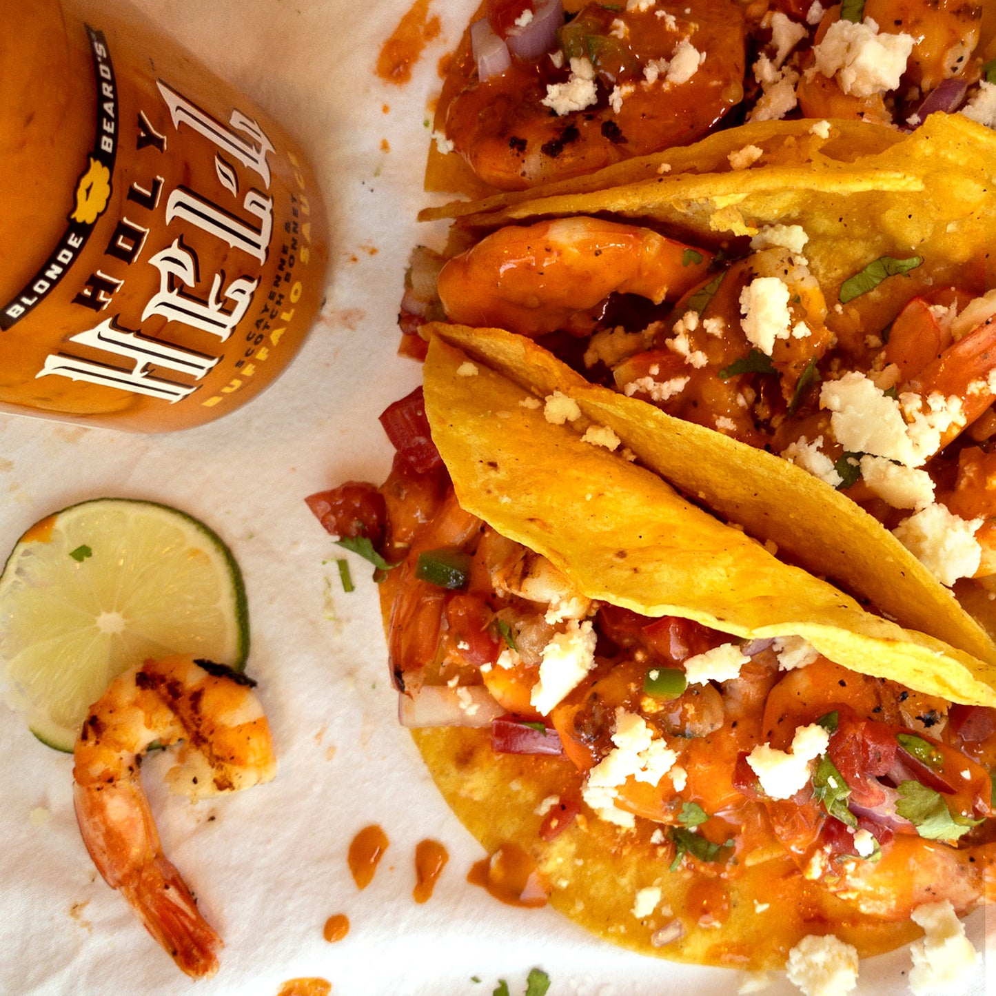 Shrimp tacos drizzled with Holy Hell extra-hot buffalo wing sauce.